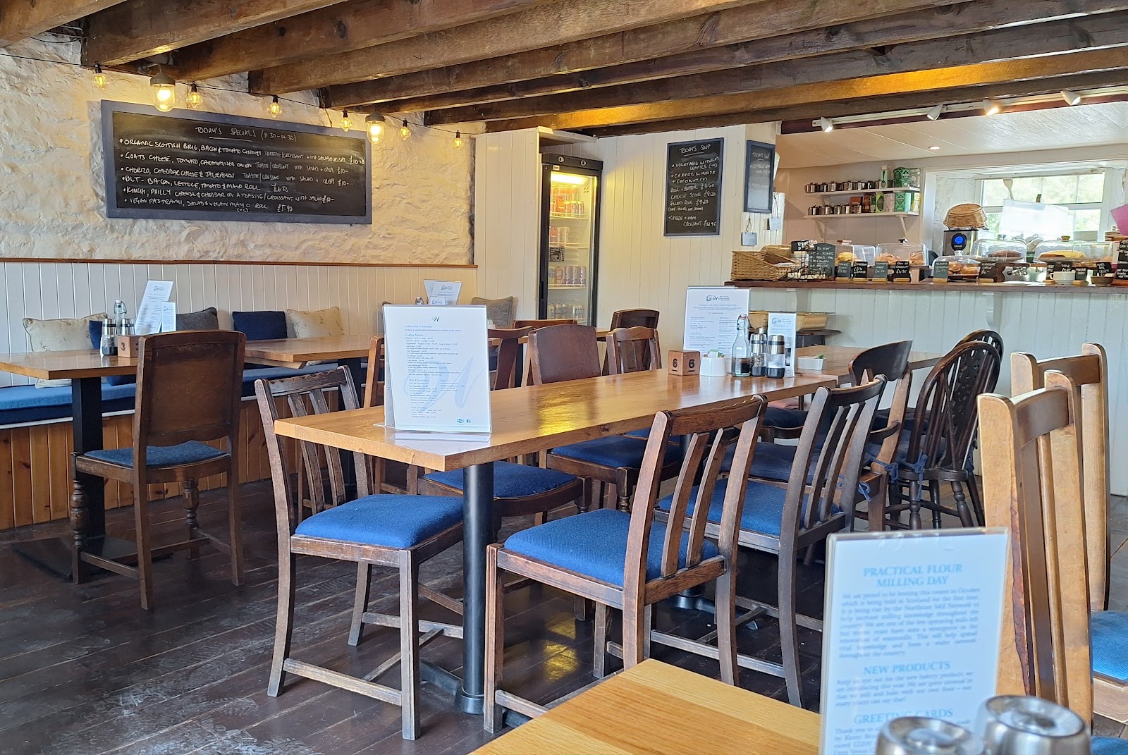 The tearoom at Blair Atholl Watermill, tables and chairs under the old beams.