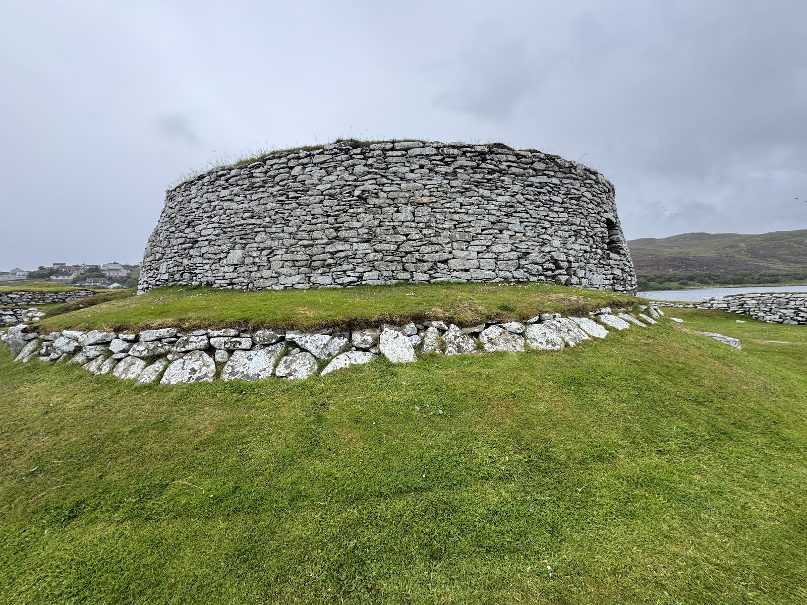 Clickimin Broch's round stone tower on its green mound.