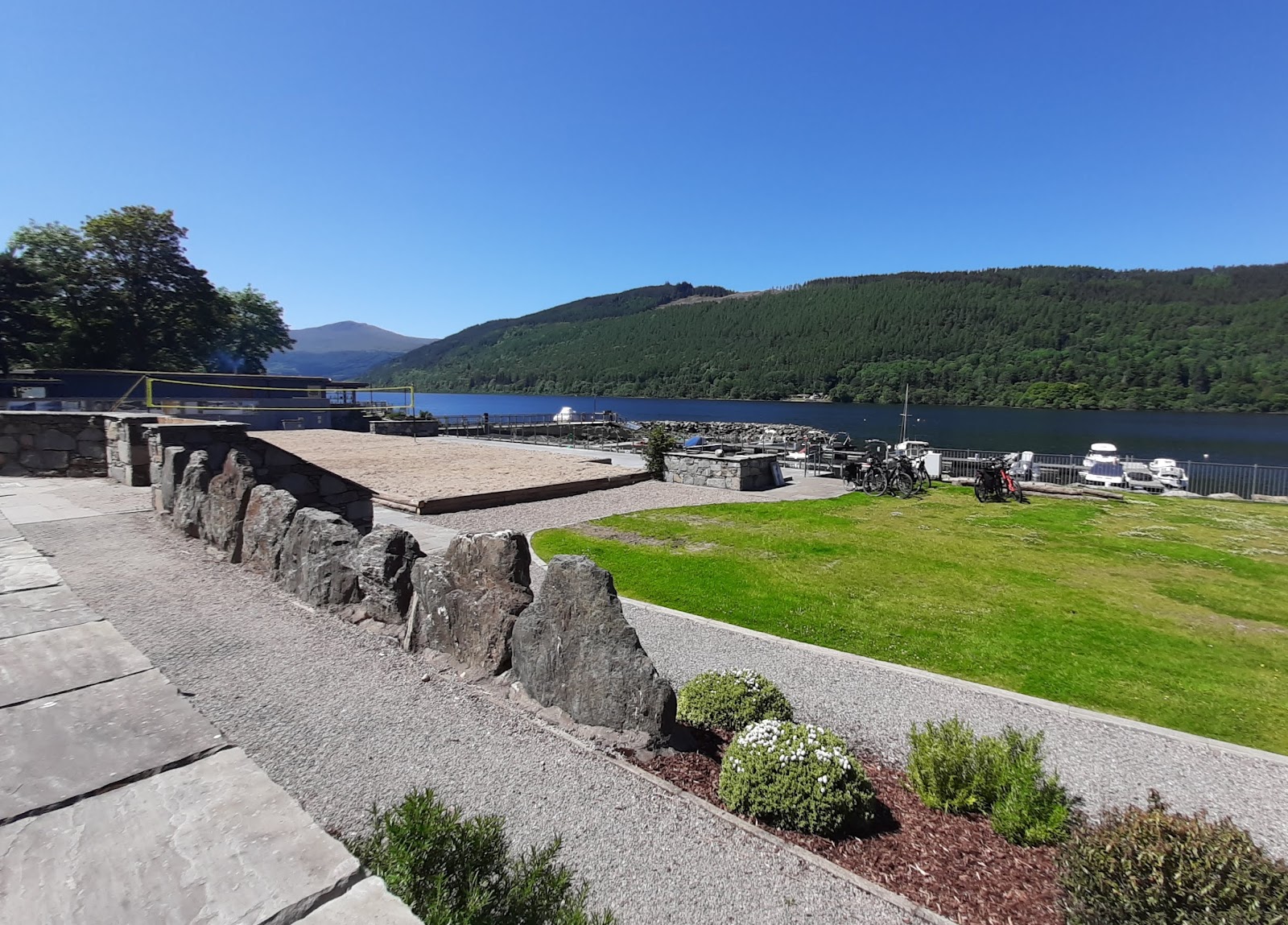 Stone paving and planting by Loch Tay at the new Crannog Centre, the loch and hills beyond.