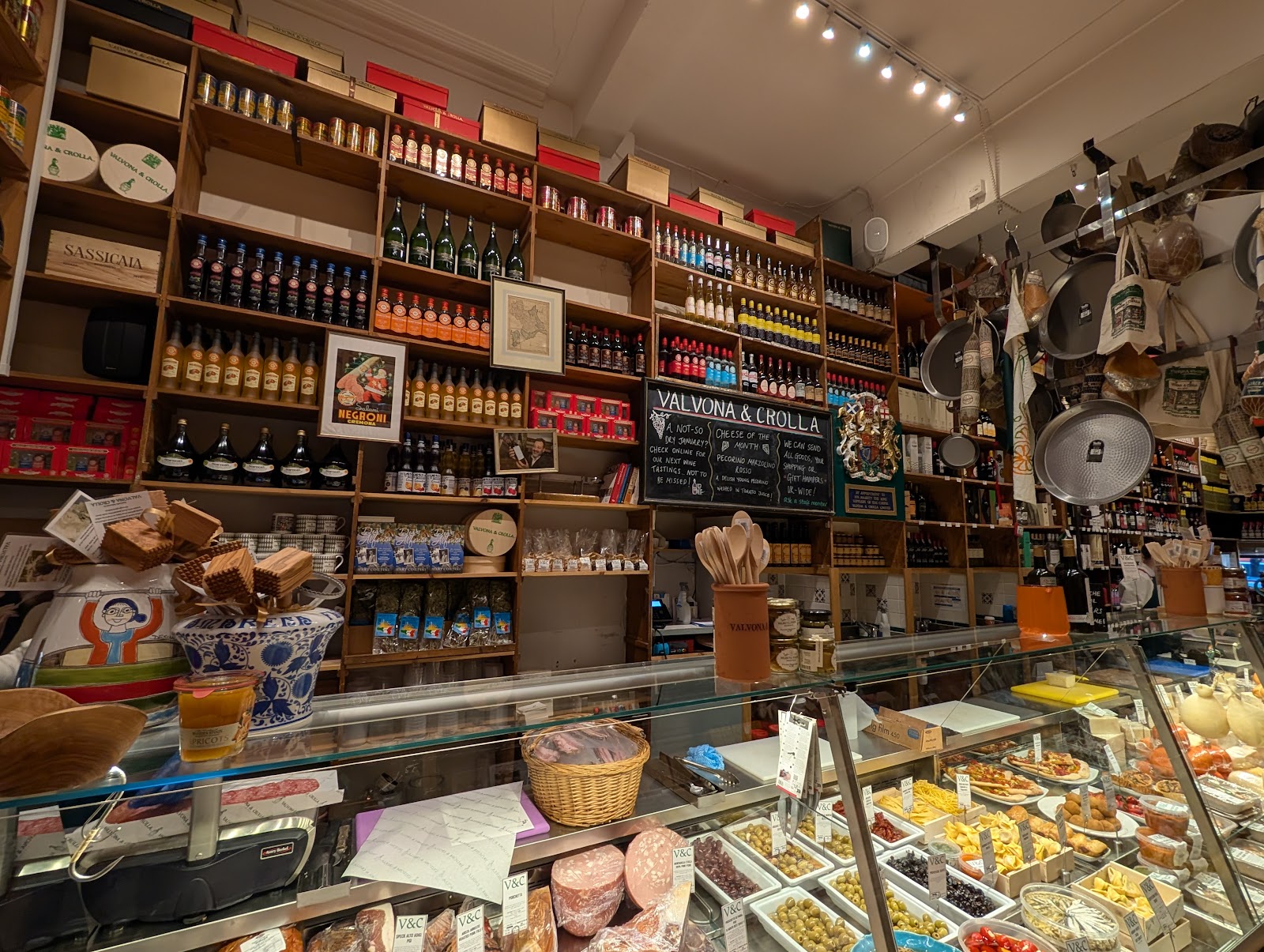 The deli counter at Valvona & Crolla on Elm Row, with cured meats, olives and pasta under the glass and shelves of Italian wine and oil up to the ceiling.