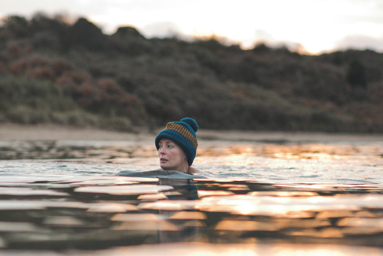 Swimmer in a woolly hat at first light