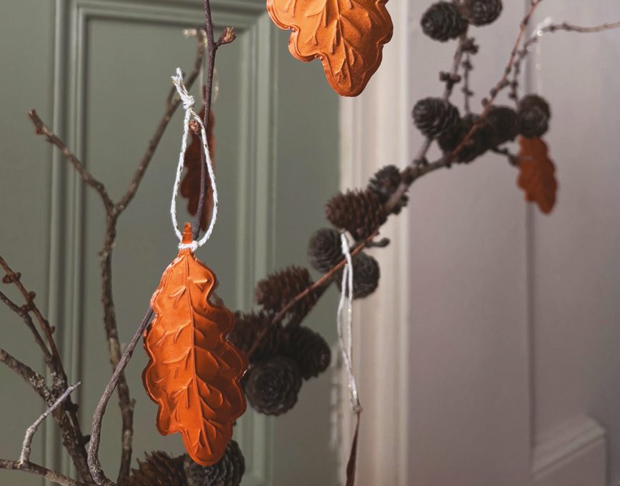 Embossed copper leaf decorations close-up on a branch
