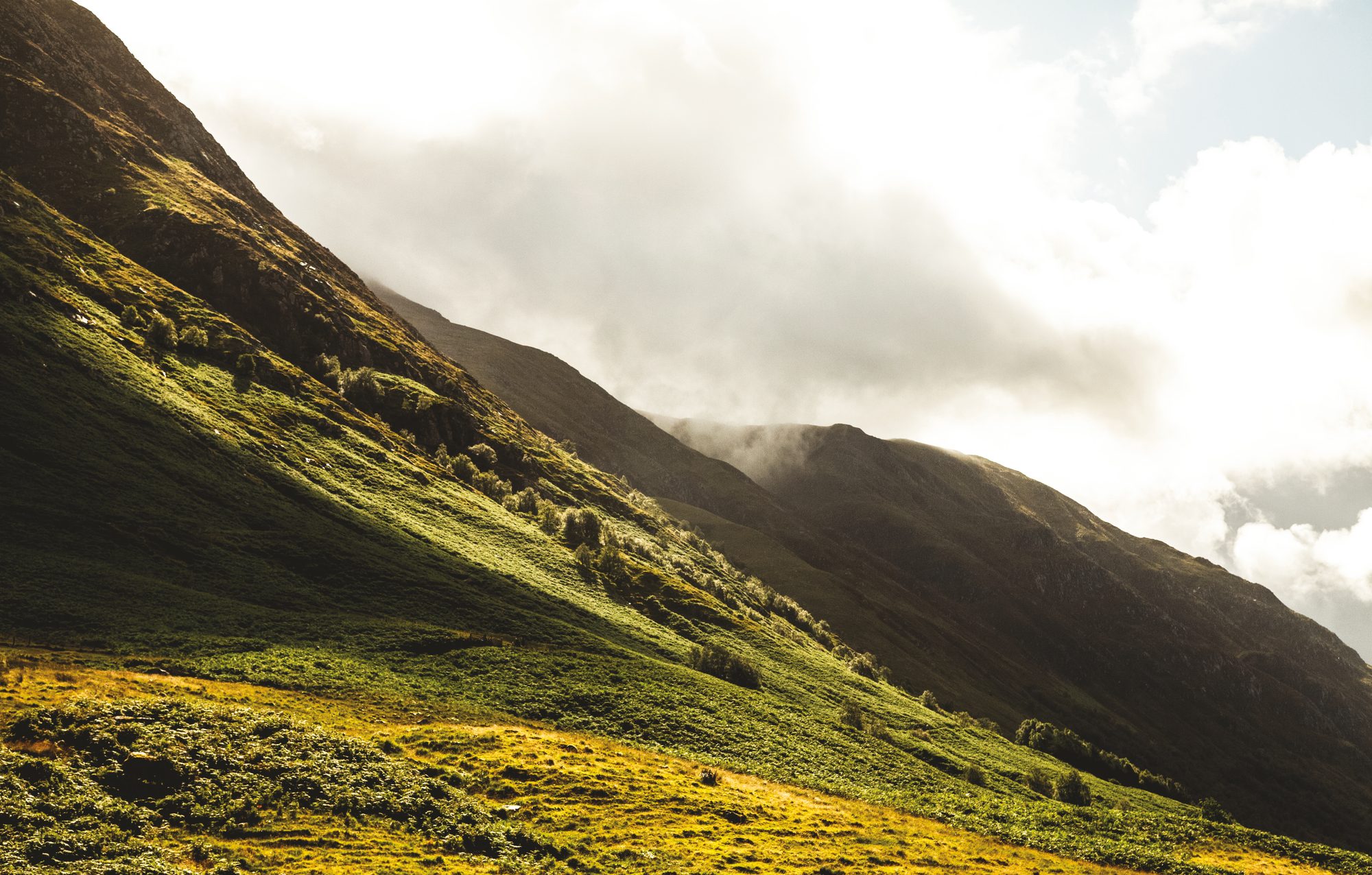 Mountain glen under low cloud with green slopes