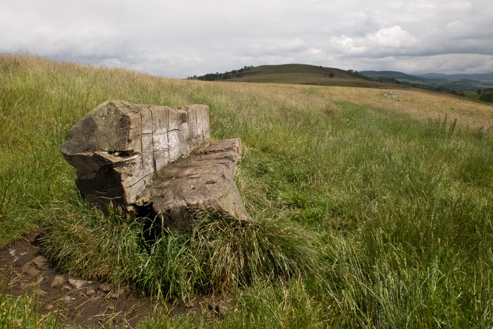 A concrete block on the grassy hill ground above Balnahard, the Finzean hills beyond.