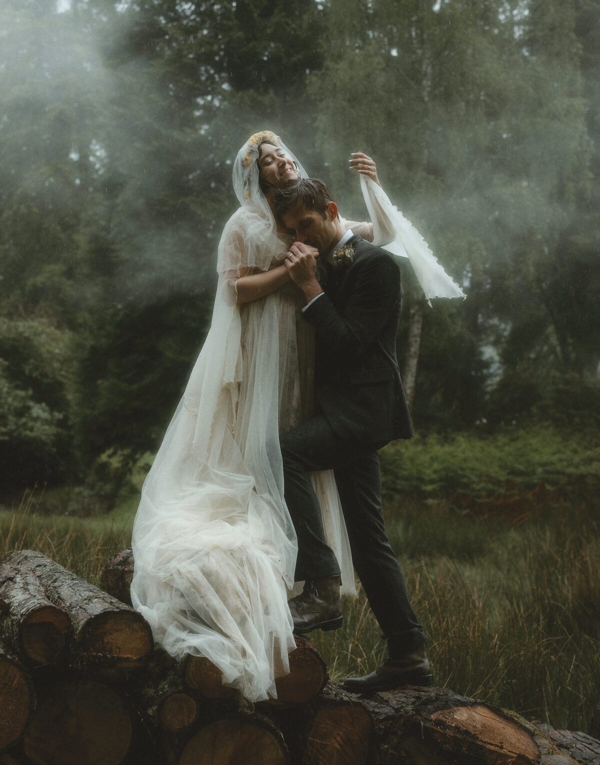 Eloping couple in wedding dress and suit on a misty loch shore