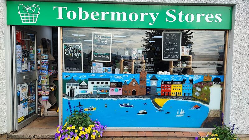 The green 'Tobermory Stores' sign over the shop window, a painted mural below.