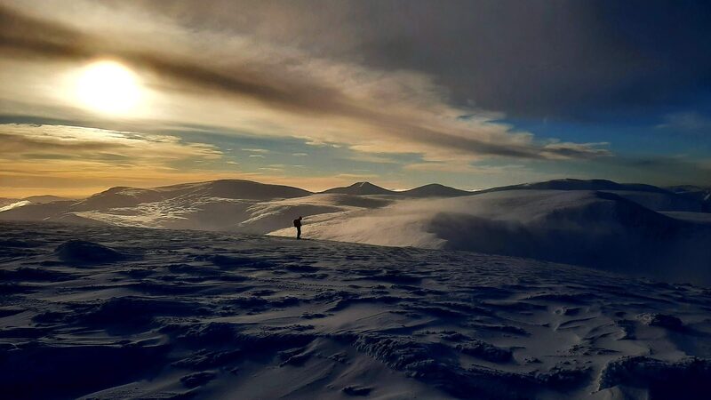 The plateau under snow at sunset, with one small figure in silhouette.