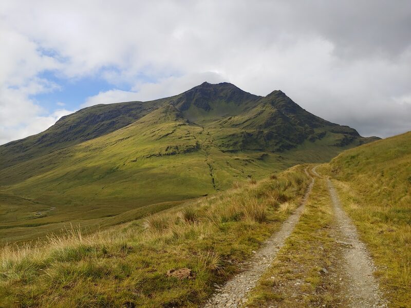 A stony track leading across grass towards Ben Lui, its two ridges rising either side of a great corrie.