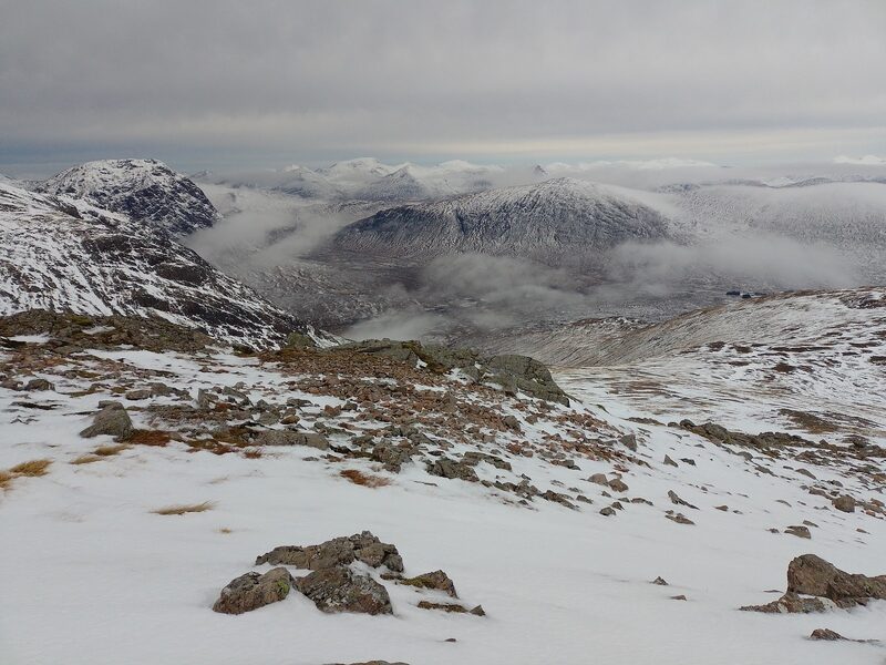 From the snowy, rocky upper hill, cloud lying in the glens and dark hills standing out of it.