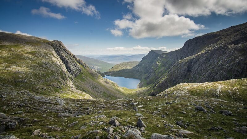 A loch lying in a deep corrie between crags, from the high ground at Beinn Dearg.