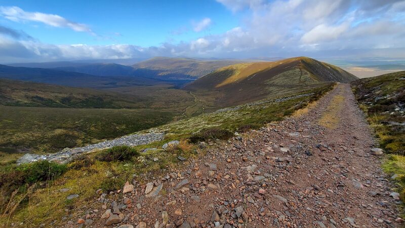 The stony track running along a heathery ridge towards the rounded top of Mullach Clach a' Bhlàir.