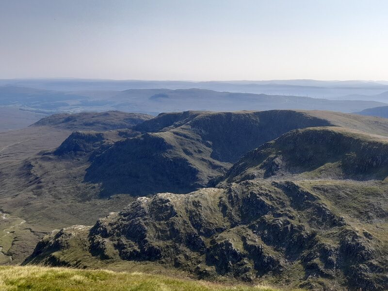 The craggy northern corrie below Càrn Ghluasaid, with moorland stretching away beyond.