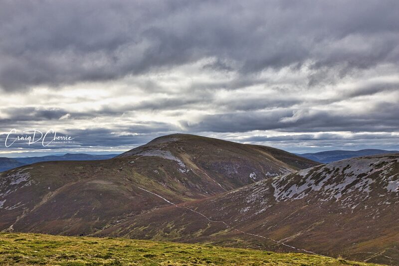 Carn an Righ whole, a rounded hill with a pale path climbing it, under heavy cloud.