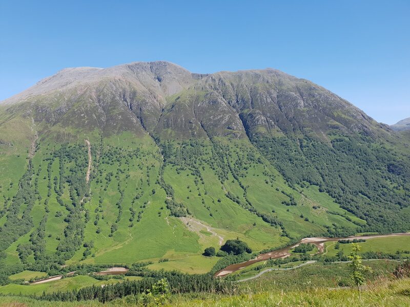 The whole hill from across the glen under a clear sky.