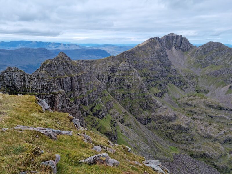 Mullach an Rathain from along the ridge of Liathach, a line of rock pinnacles in front of it and a deep corrie below.