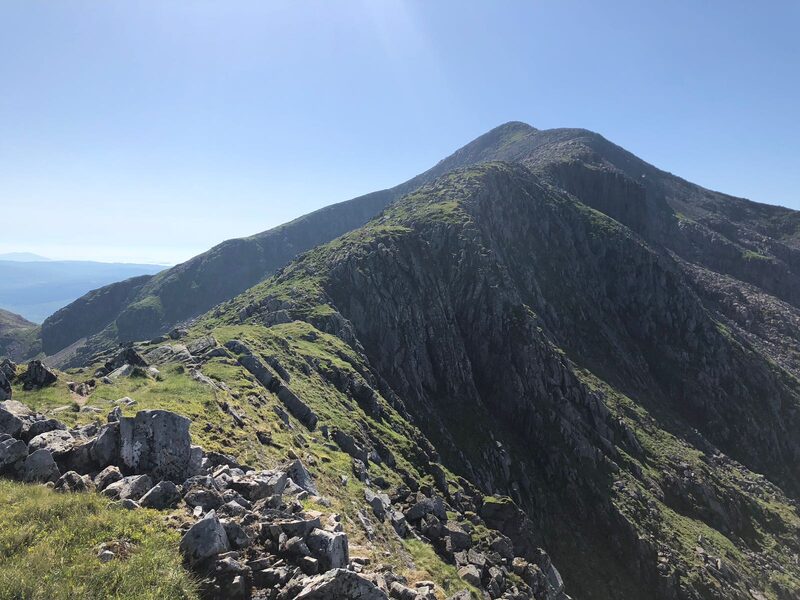 The rocky ridge leading up to the summit of Ben Cruachan under a clear sky, sea far below at the left.
