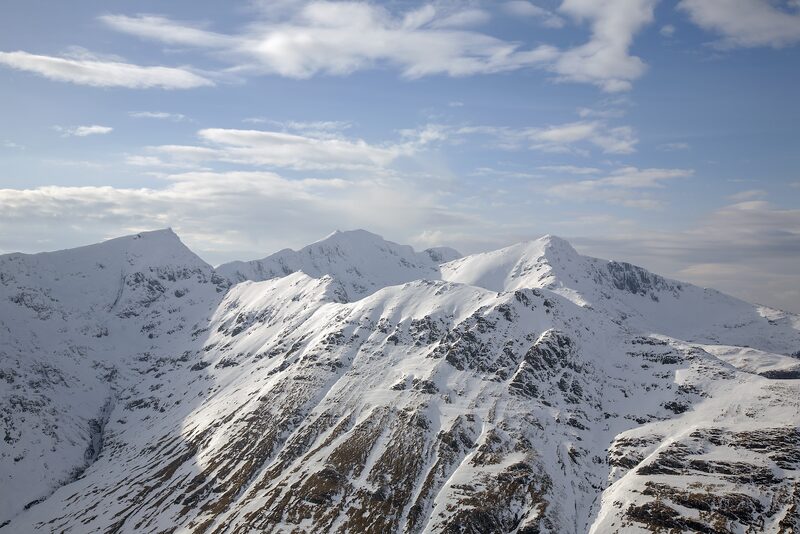 Snow-covered summits and ridges under a pale winter sky.