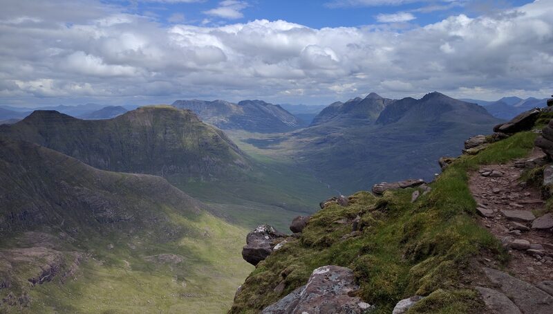 A stony path on the edge of Beinn Alligin's ridge, looking down a long glen to the neighbouring Torridon hills.
