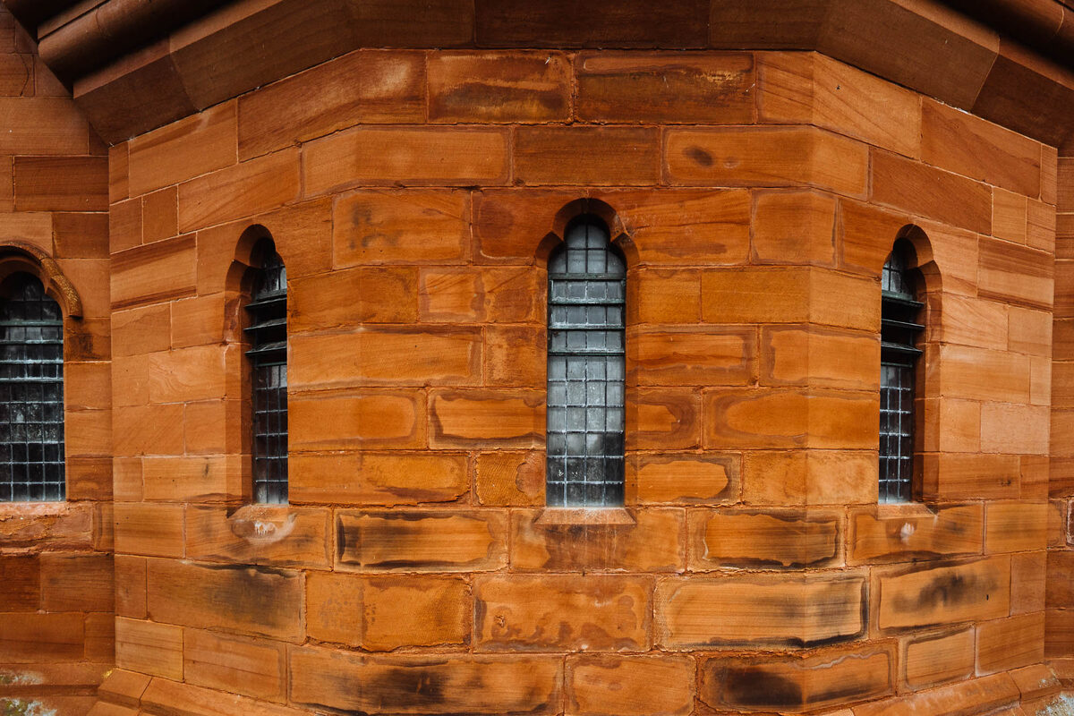 Red sandstone walls and tall windows.