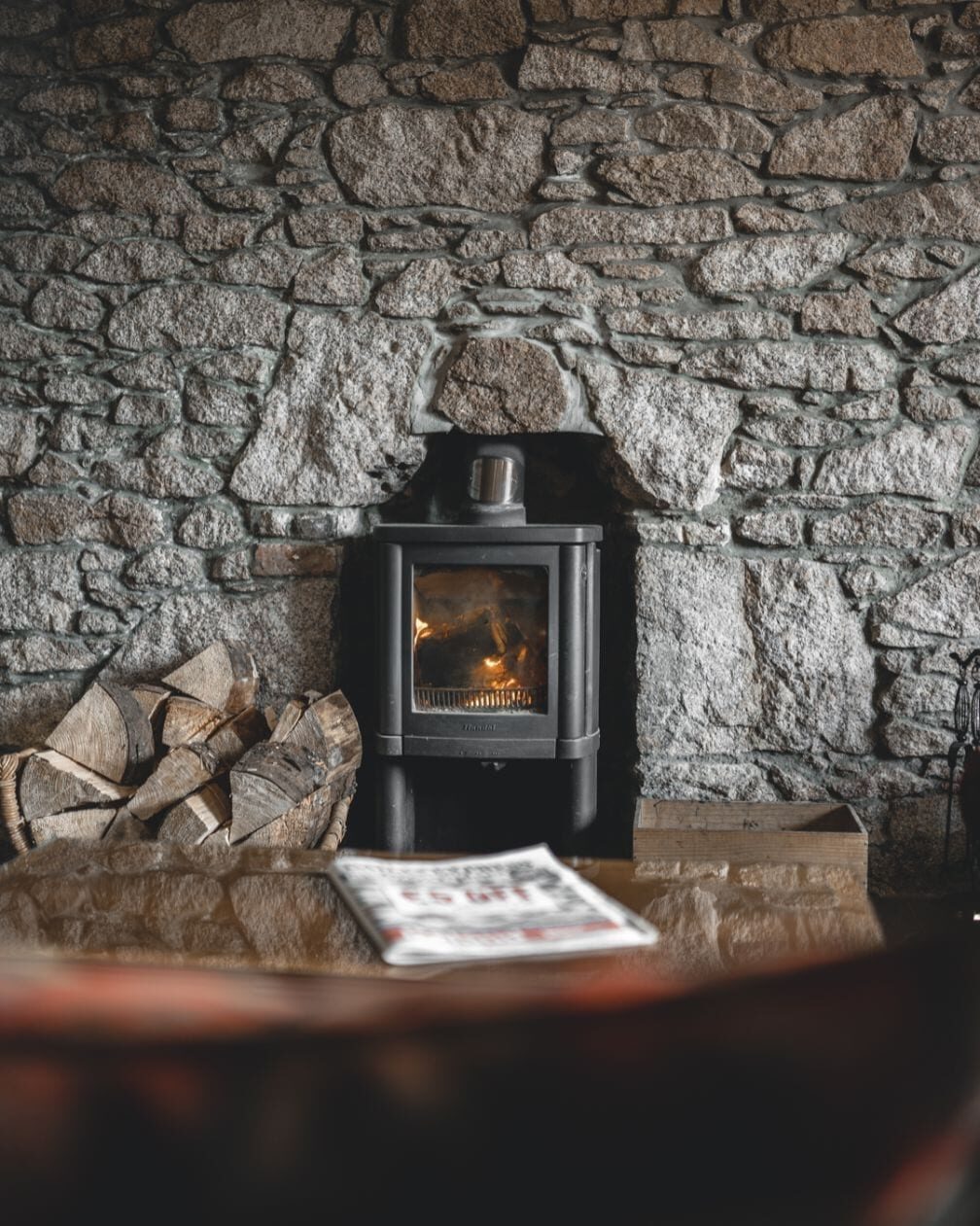 A wood-burning stove set into an old stone wall at the Kilmarnock Arms.
