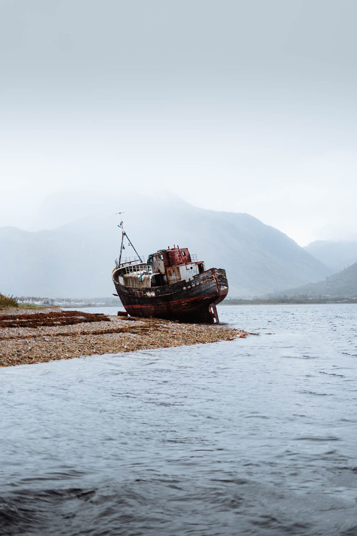 The Corpach wreck on the beach, its hull streaked with rust, the loch behind.