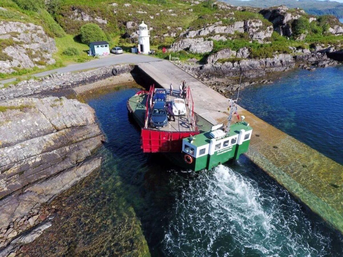The ferry backed onto the slipway by the little white lighthouse, its wake churning.