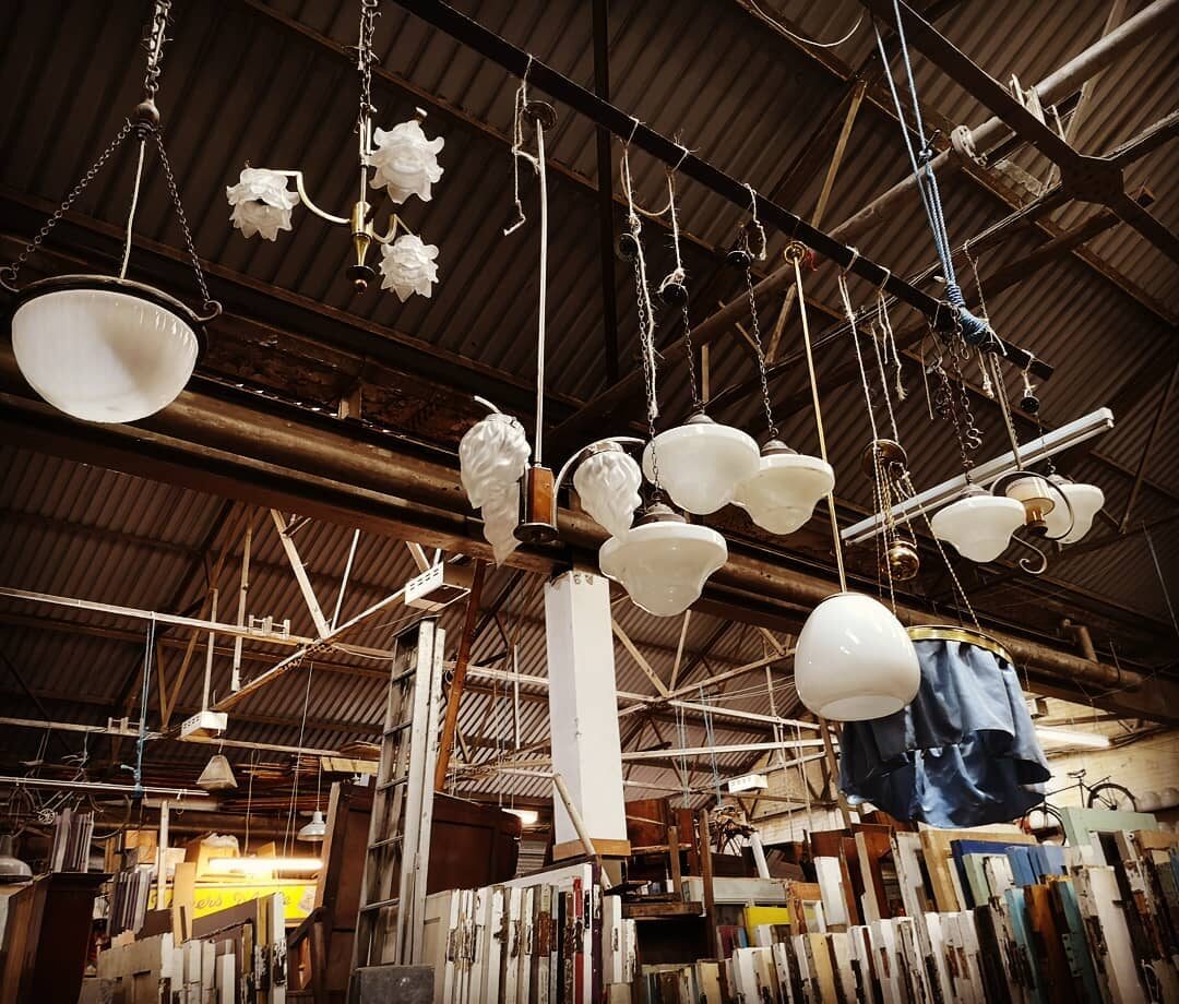 Glass lampshades and pendant lights hanging from the warehouse roof.