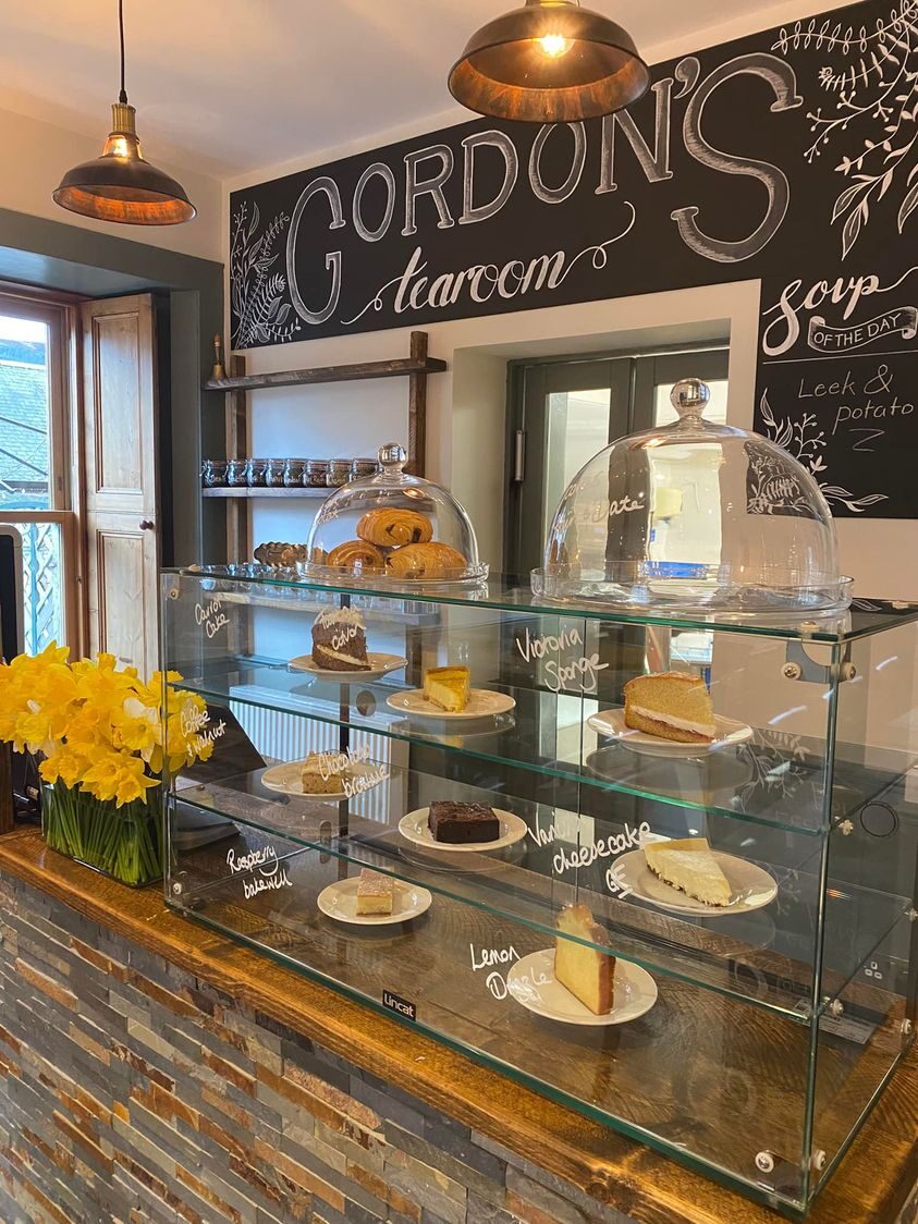 Gordon's glass counter of cakes under its chalkboard sign in Braemar.