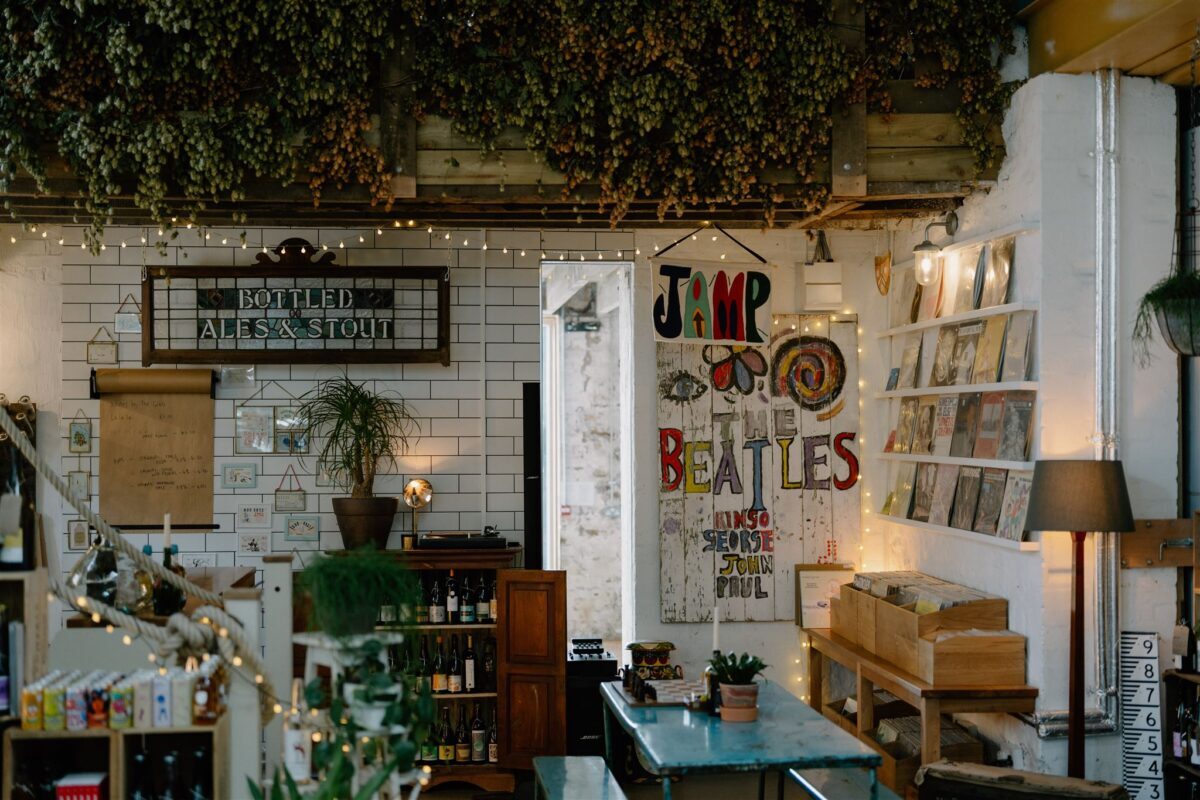 Bar interior with "Bottled Ales & Stout" sign and colourful Beatles artwork