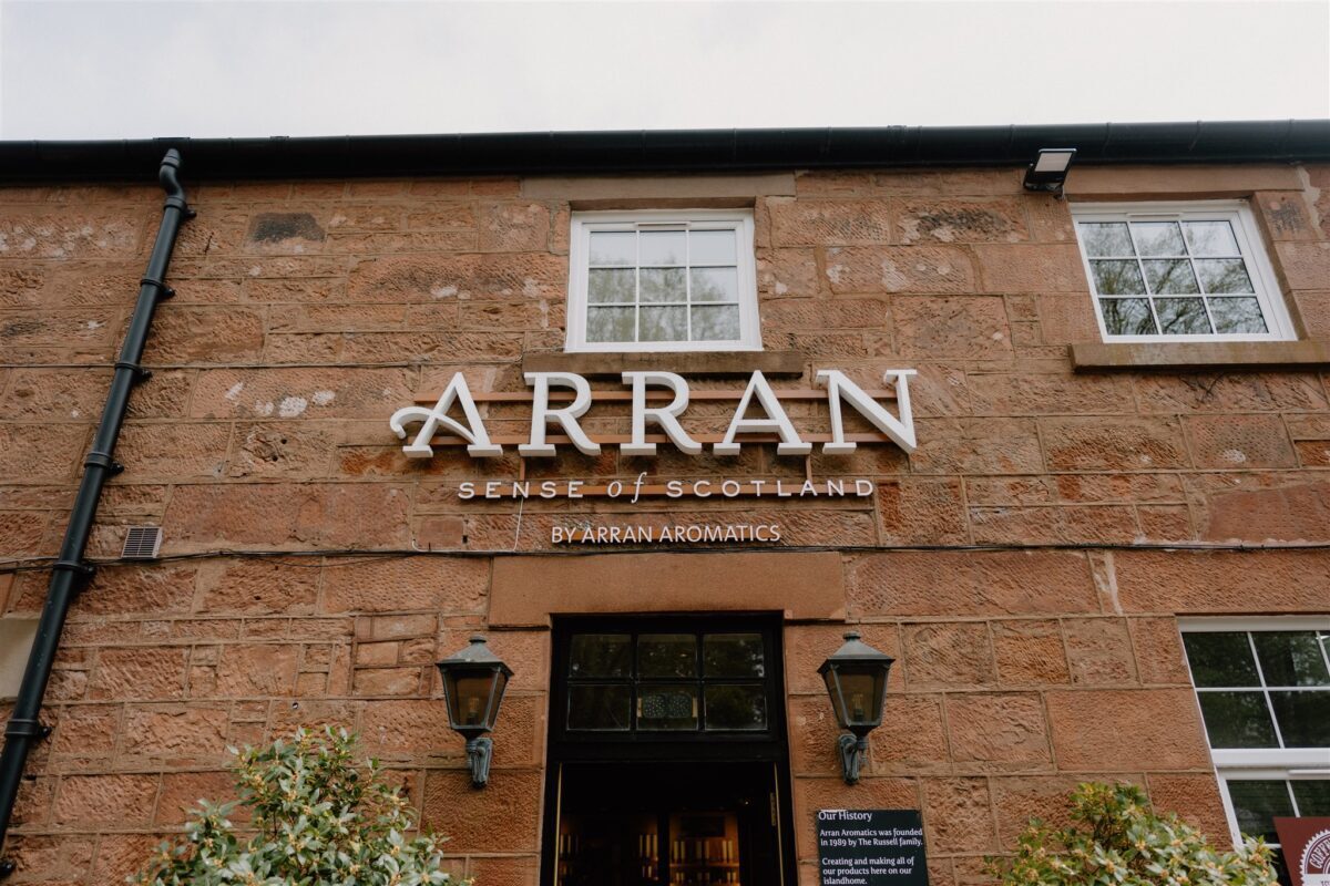 Sandstone building with sign reading "Arran, Sense of Scotland, by Arran Aromatics