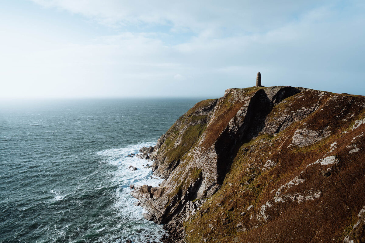 The American Monument on its cliff top at the Mull of Oa, the sea breaking on the rocks below.