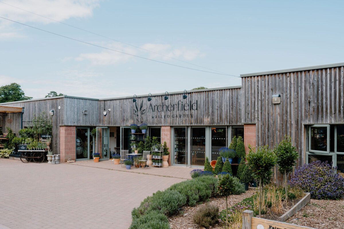 Timber-clad Archerfield Walled Garden building with plants displayed outside the entrance