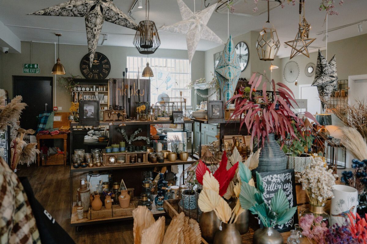 Star-shaped lanterns hang above shelves of dried flowers, clocks and ornaments in a gift shop