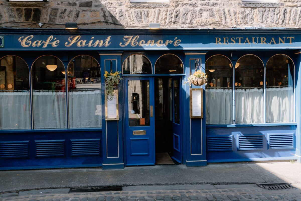 Blue-fronted Cafe Saint Honoré restaurant with arched windows and open door