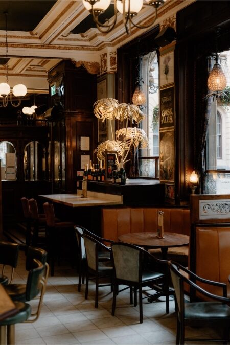 Ornate ceiling and leather booths inside a pub with a "Cask Ales" sign