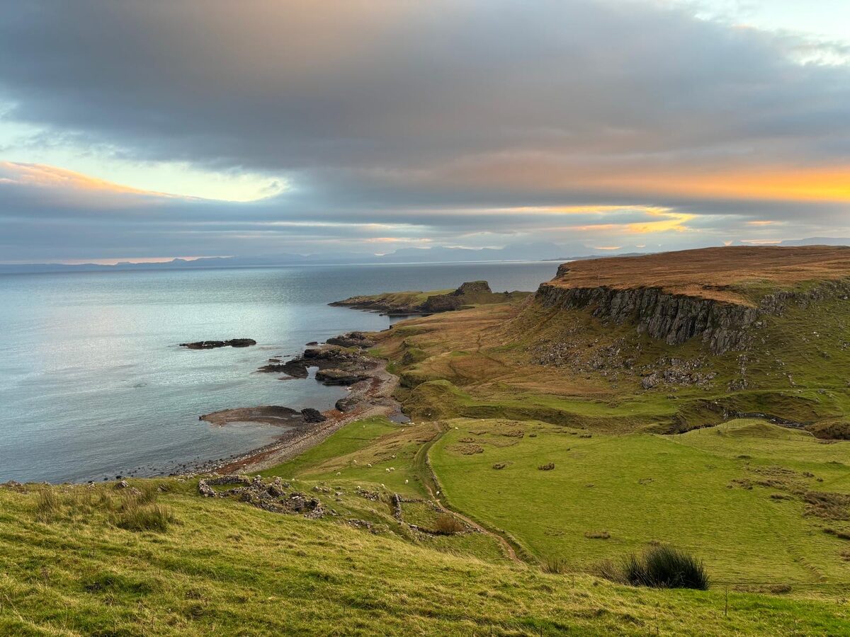 The view from Half of One over the coast to Brothers Point, the sky lit gold at the horizon.