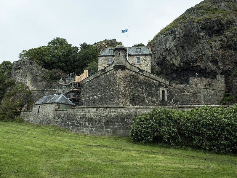The castle buildings and walls below the rock.