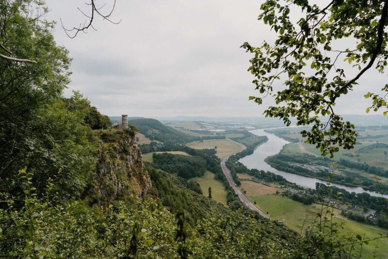 Small tower on a cliff edge overlooking a winding river valley