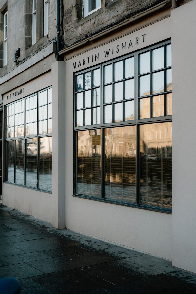 Restaurant Martin Wishart's white frontage with large paned windows on Leith's waterfront