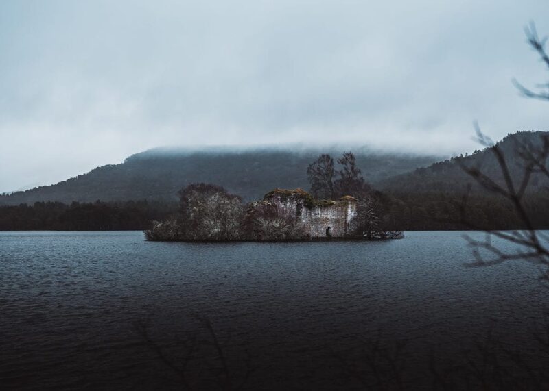 Ruined castle on a small loch island beneath low mist