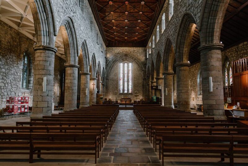 Stone pillars line the nave towards the altar under a timber roof