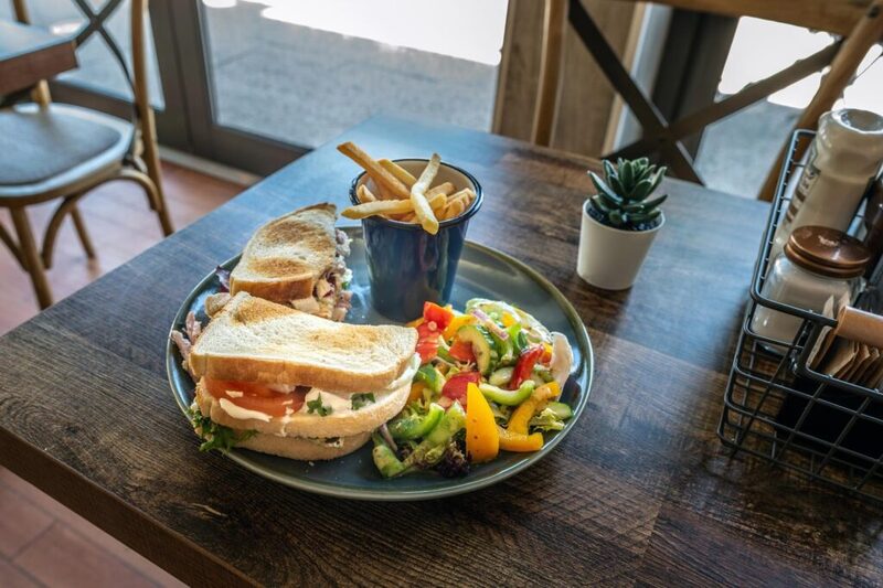 Toasted sandwich with salad and chips on a café table