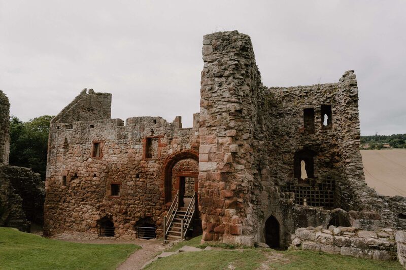 Ruined stone castle with wooden staircase leading to an arched doorway