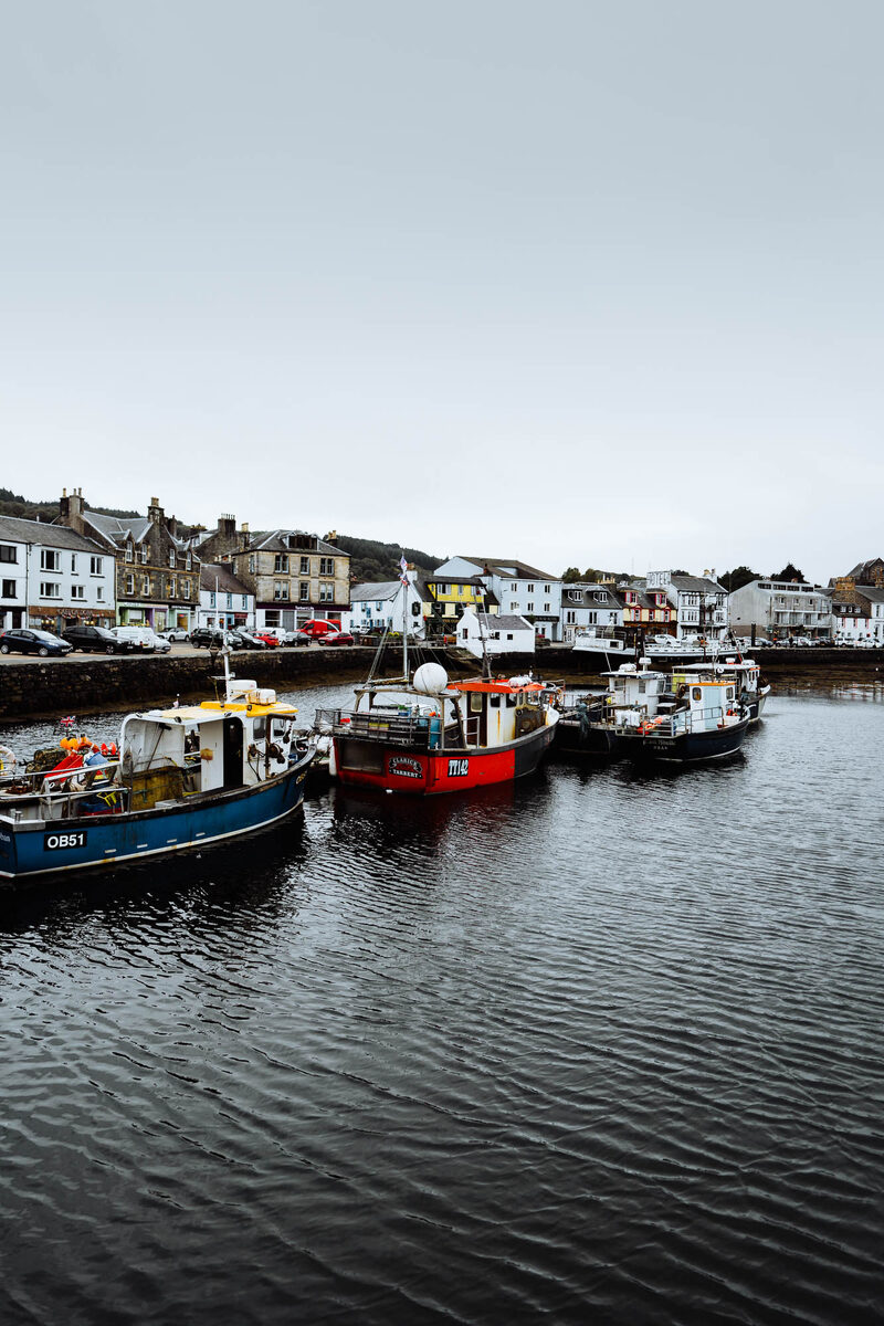Fishing boats OB51 and ME moored in Tarbert harbour, waterfront buildings behind