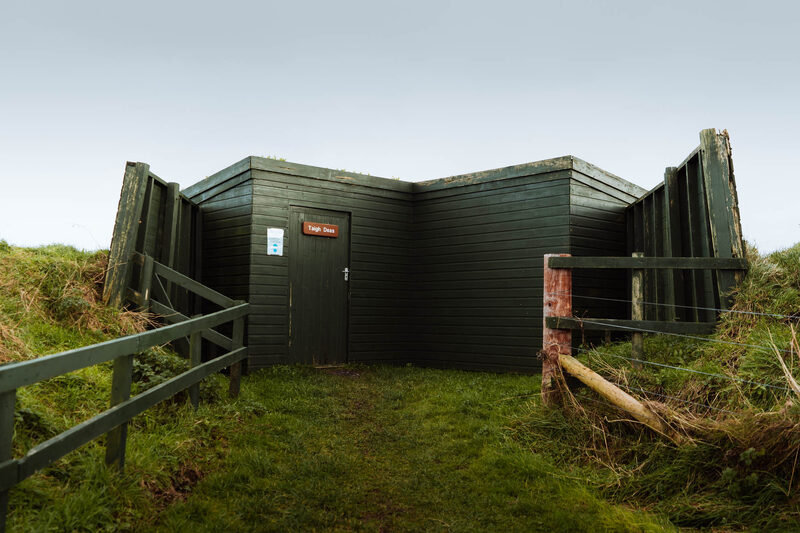 The dark green hide at Loch Gruinart, set low in the grass.