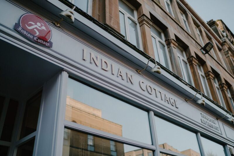 Sandstone building shopfront with "Indian Cottage" signage above large windows