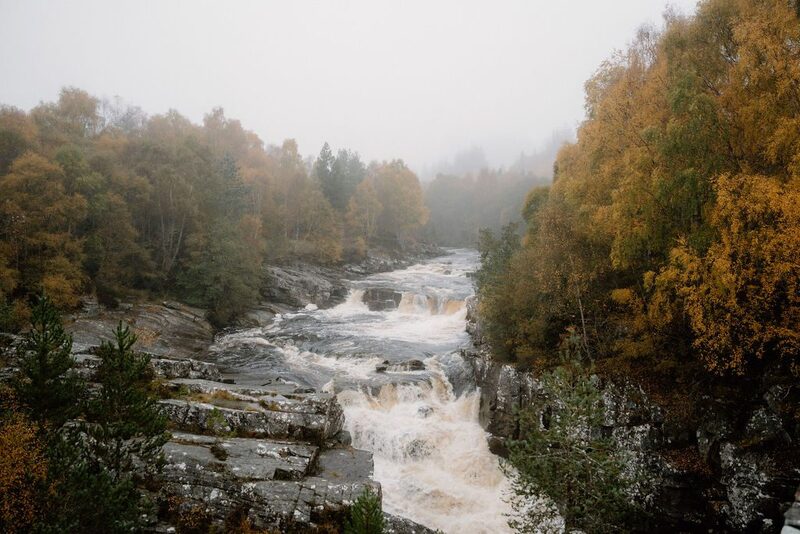River tumbling over rocky falls through a mist-covered autumn woodland